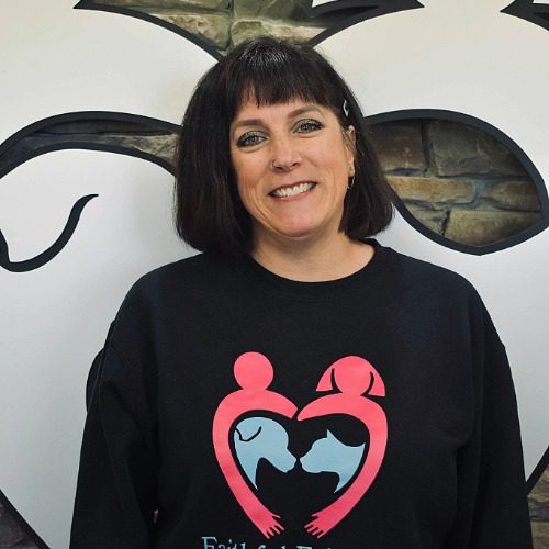 Shannon - female with shoulder length brown hair with bangs wearing a logo branded shirt for Faithful Friends